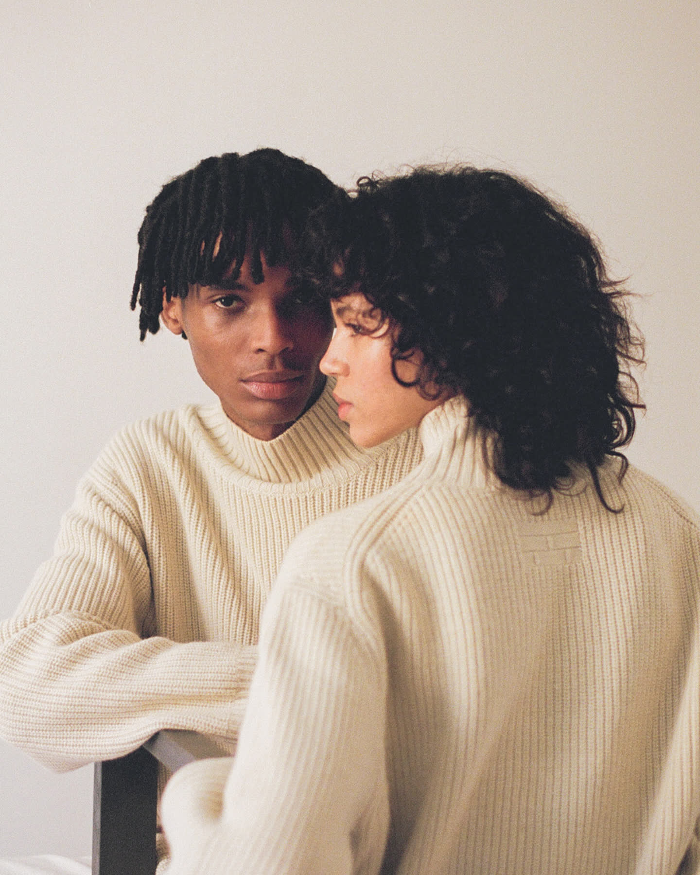 Two models facing each other in cream rib knit for À deux.