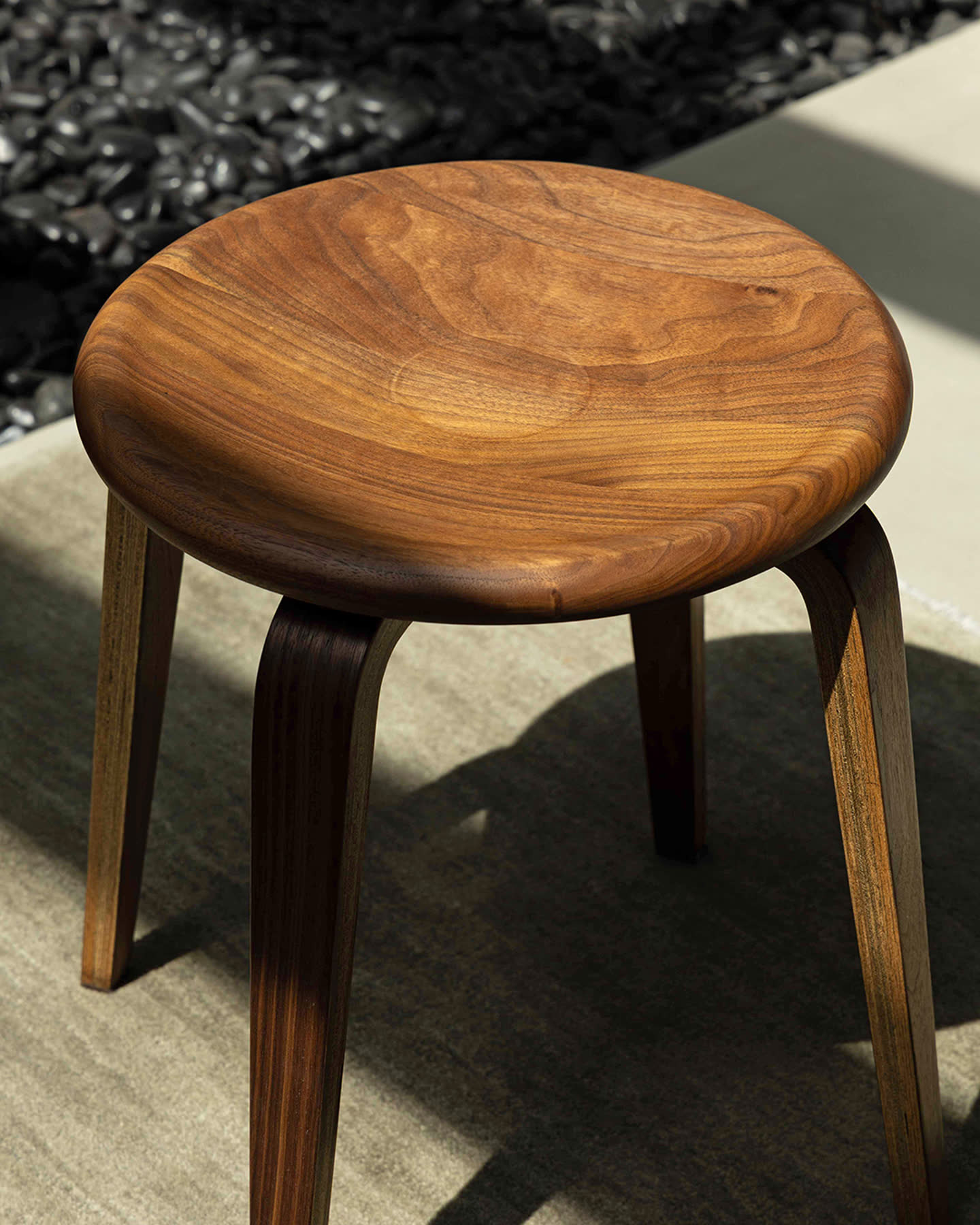 A close view of the Bistro stool&rsquo;s carved walnut seat.