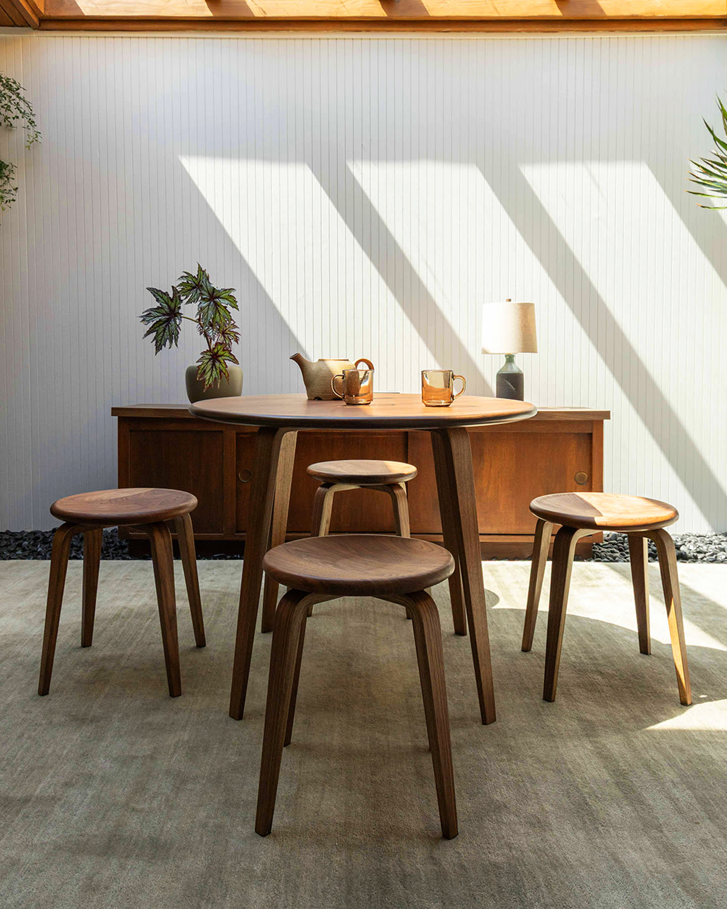 The Bistro Collection table and stools in a sunlit room.