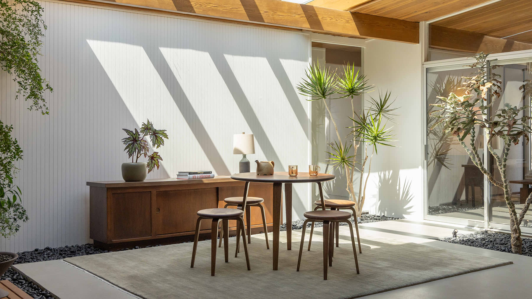 The Bistro Collection table and stools in a sunlit interior.