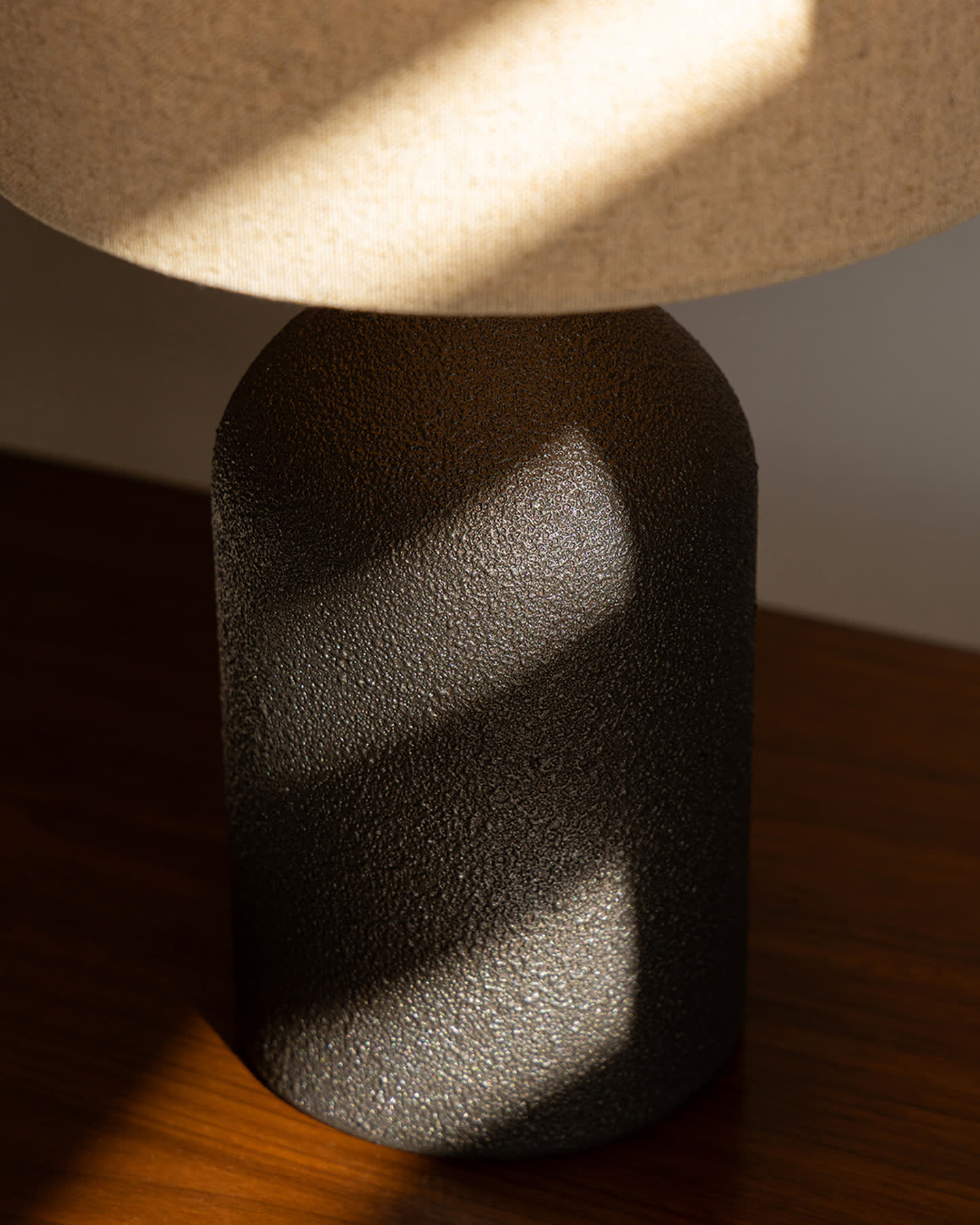 Close detail of the Bottle Table Lamp&rsquo;s hand-finished bronze stoneware base.