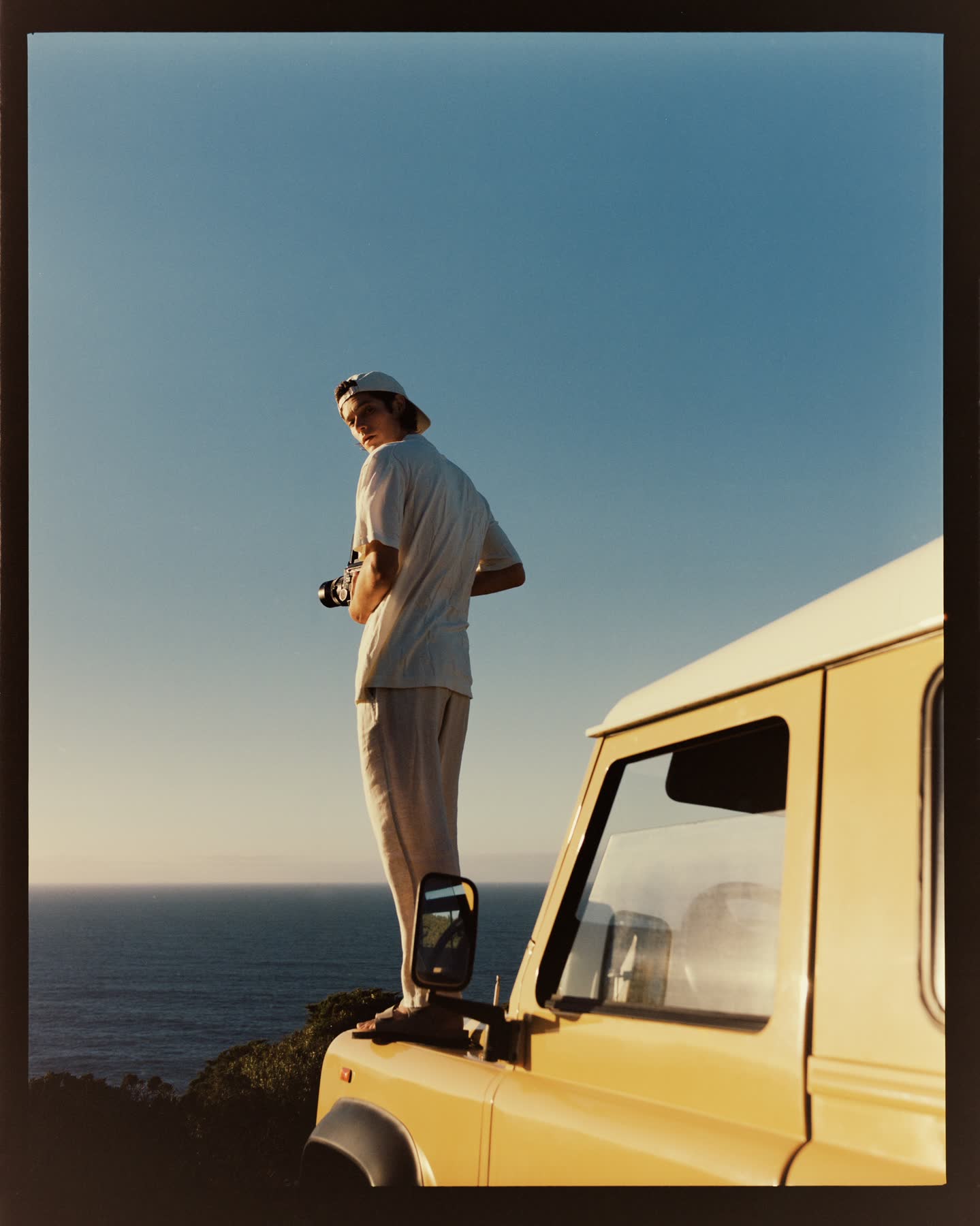 Conrad Leadley standing on the yellow vehicle above the Atlantic at Cabo da Roca.