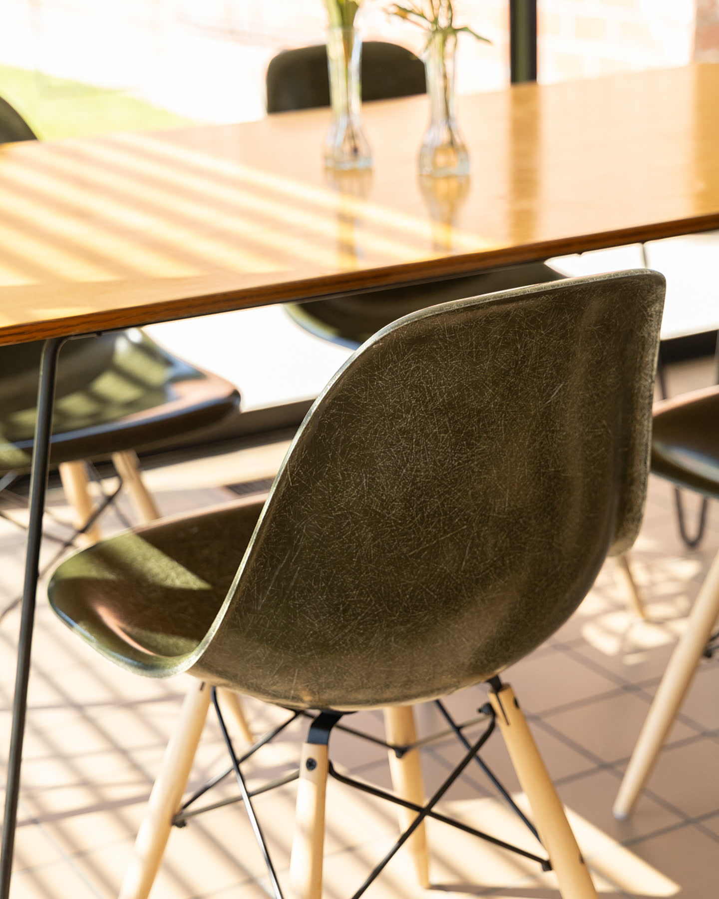 Close detail of a dark molded chair beside the dining table.