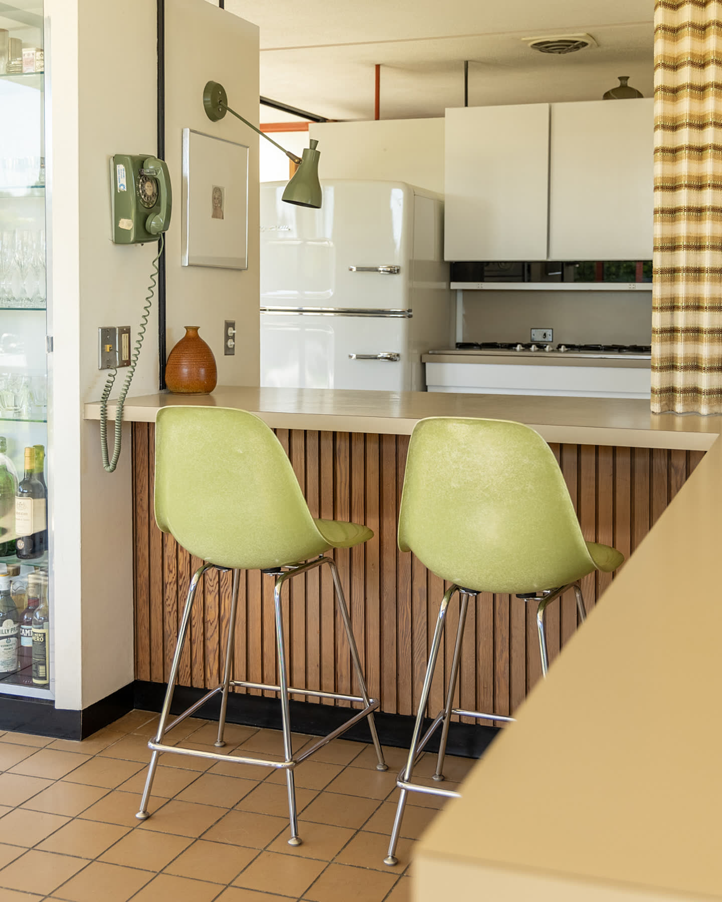 Green bar stools and the original kitchen at Case Study House #16.