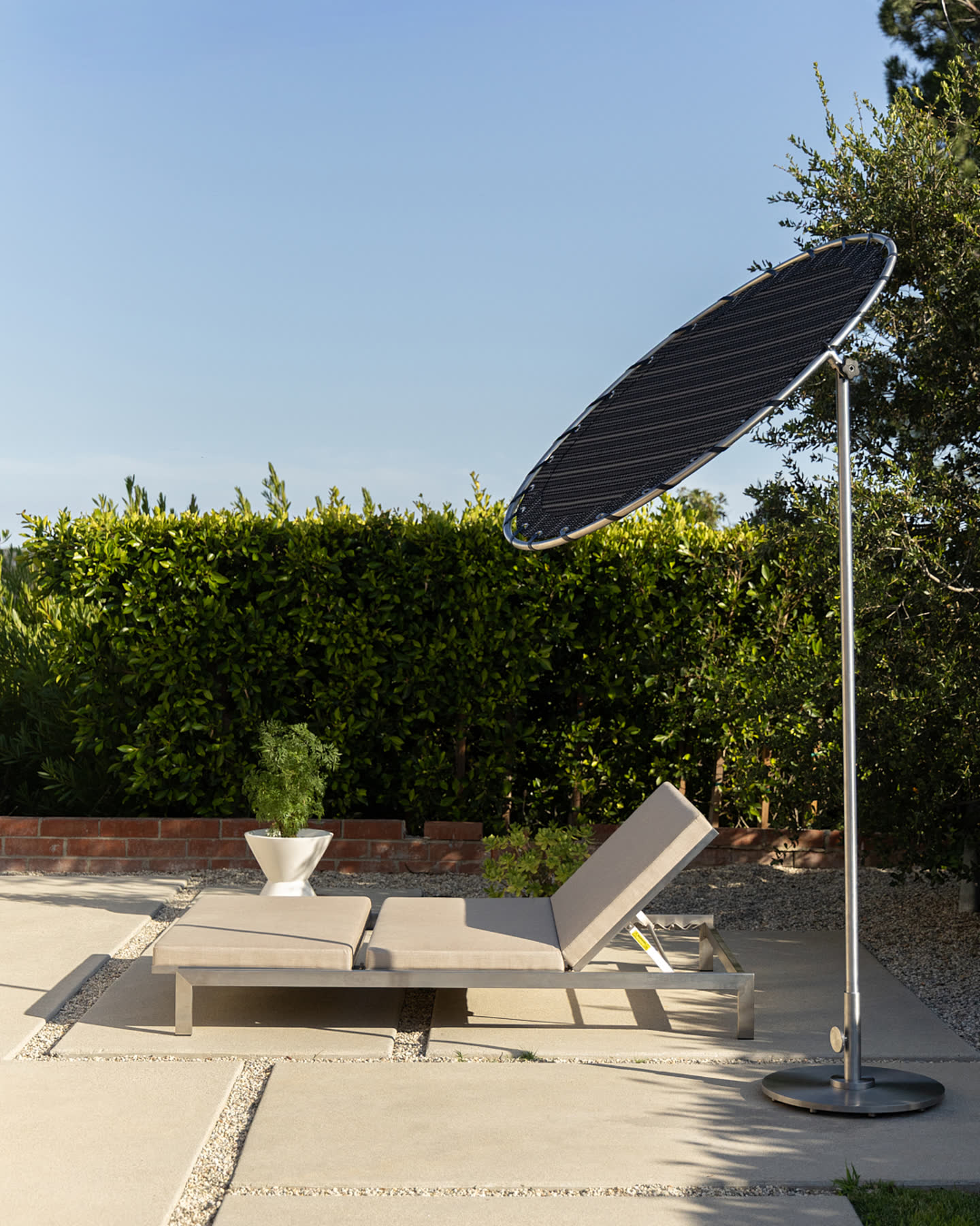 A daybed and parasol in the afternoon light.