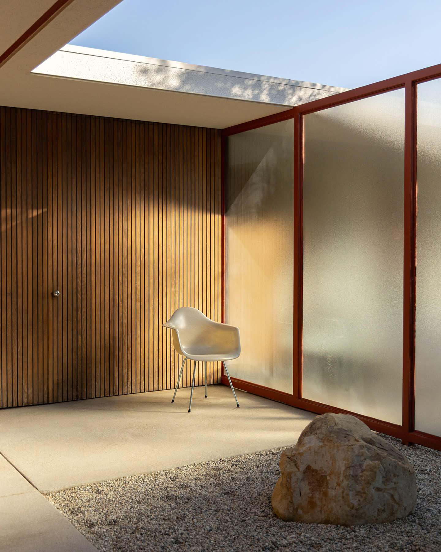 A molded Modernica chair in a quiet courtyard at Case Study House #16.