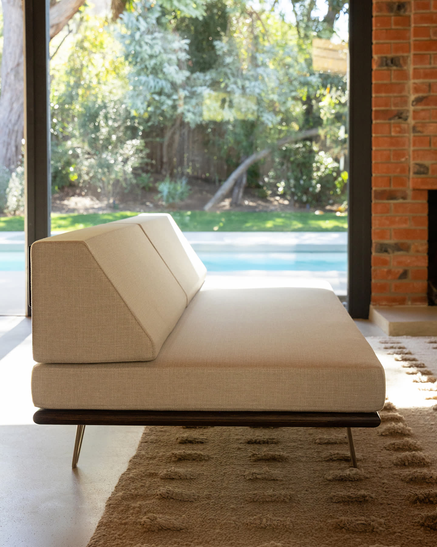 A Modernica sofa opening toward the garden through the Eichler Post & Beam windows.