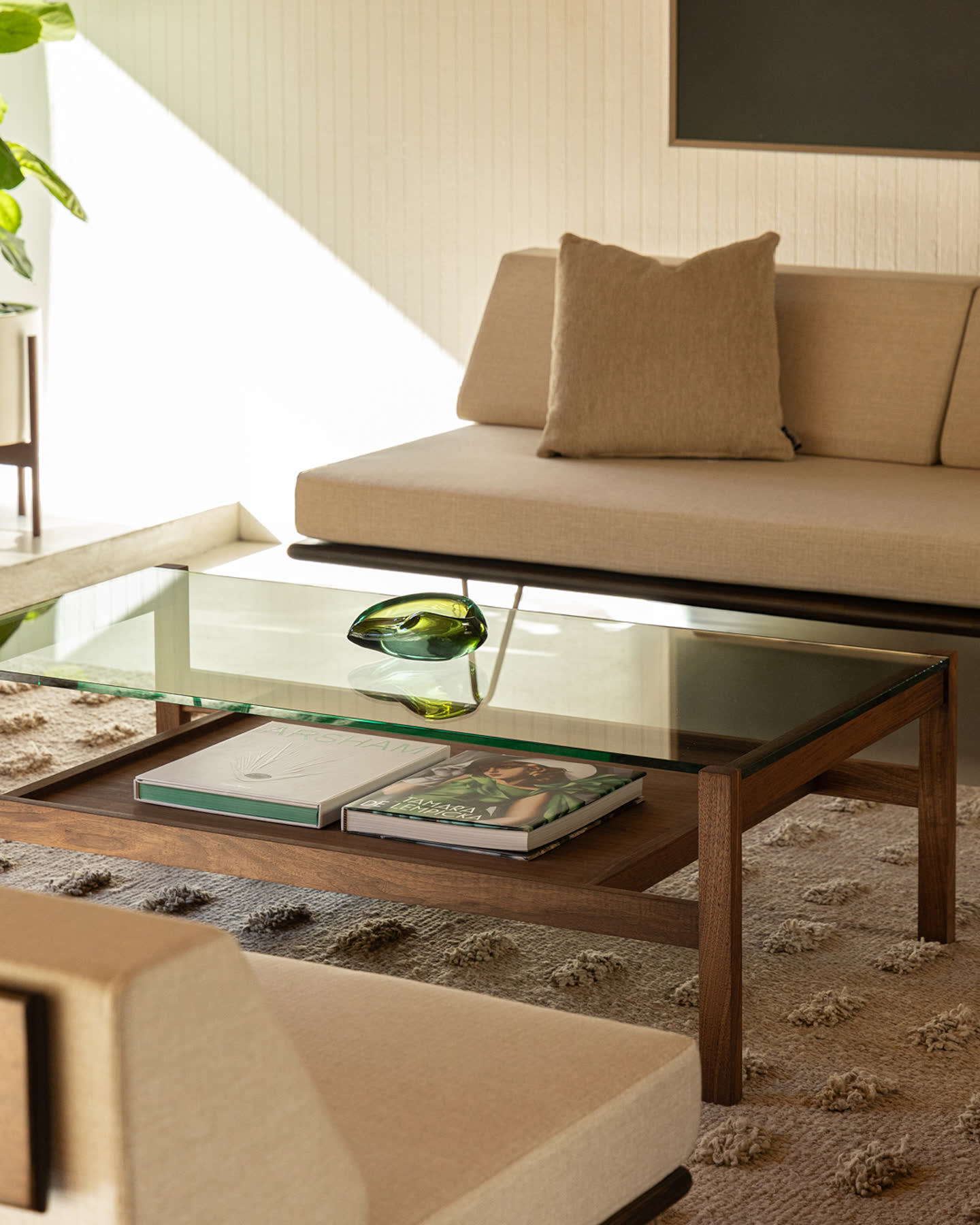 A Modernica glass coffee table and sofa in the Eichler Post & Beam living room.