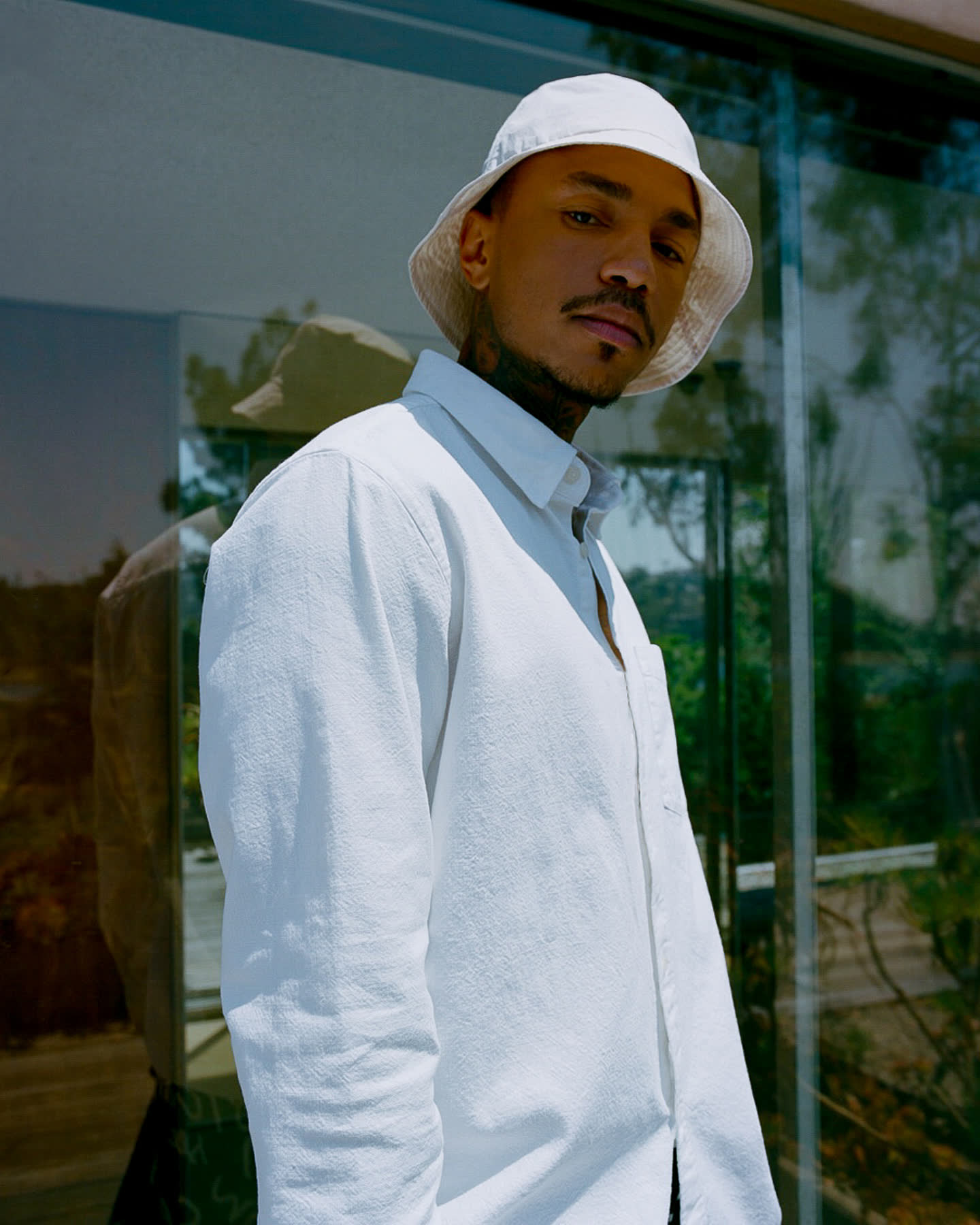 Sean Lyles photographed beside the glass exterior of the Neutra VDL House for Zara.