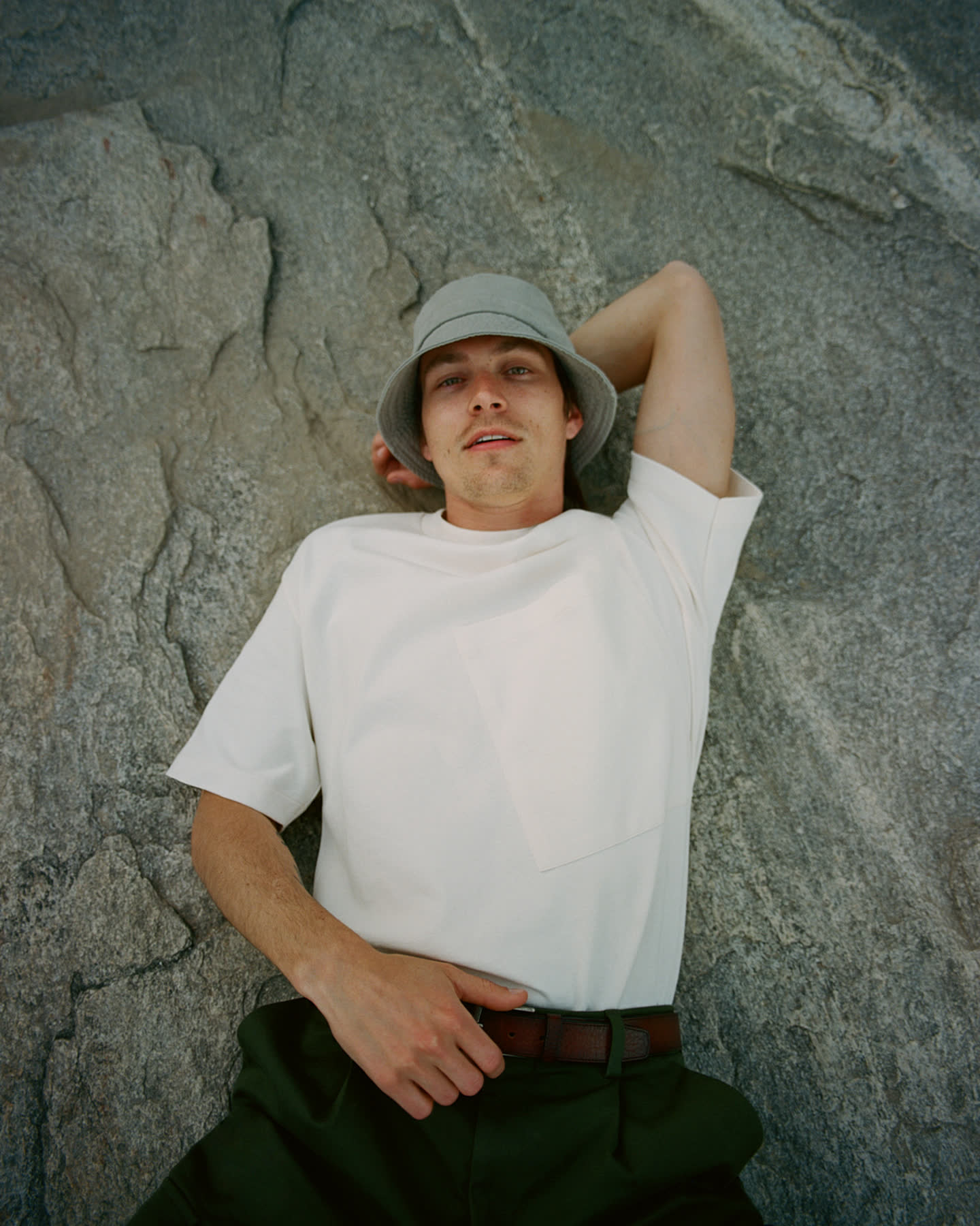 Model reclining against desert rock for Palm Springs by Zara.