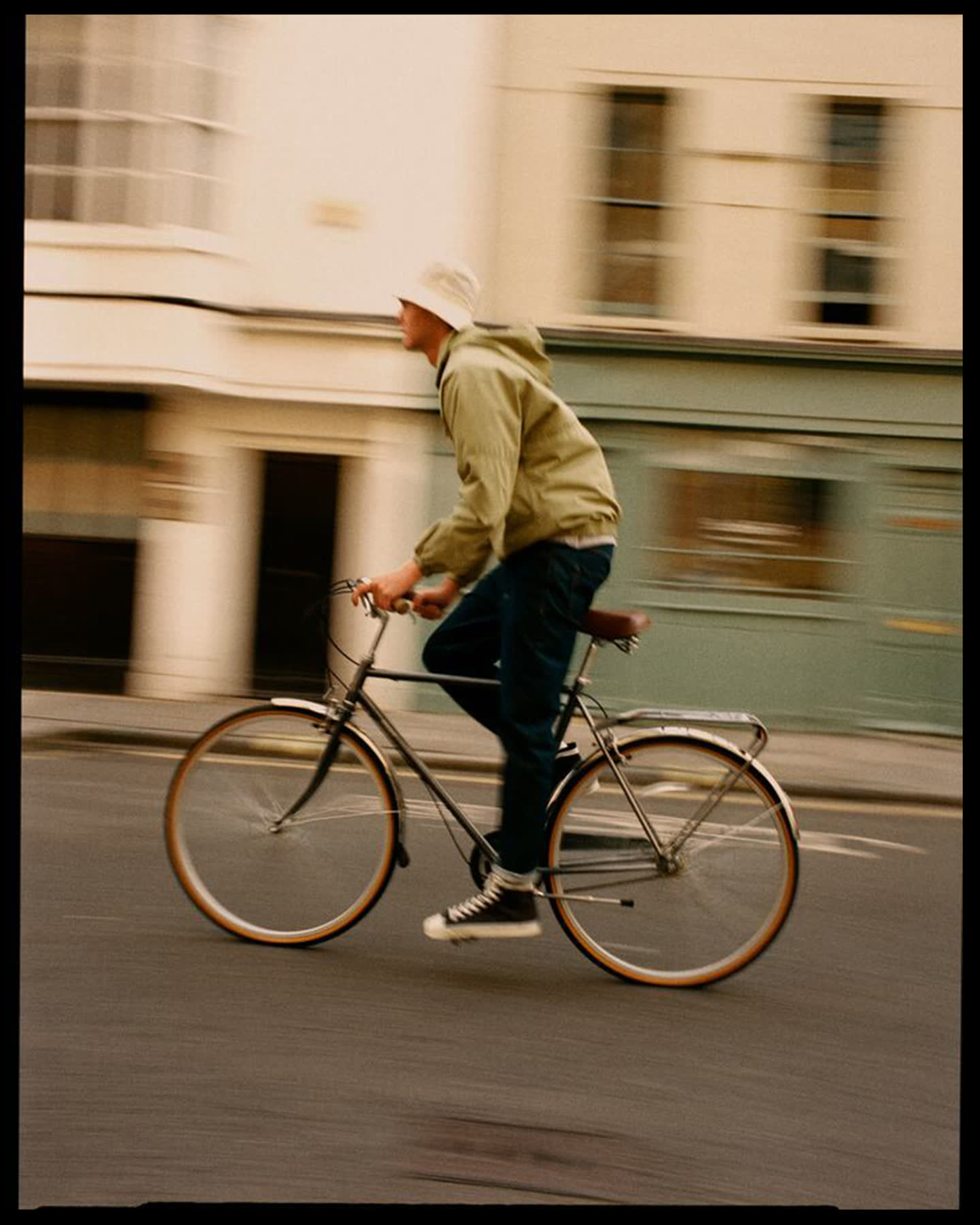 Darwin Gray riding a steel-framed bicycle through London for Portobello Road.