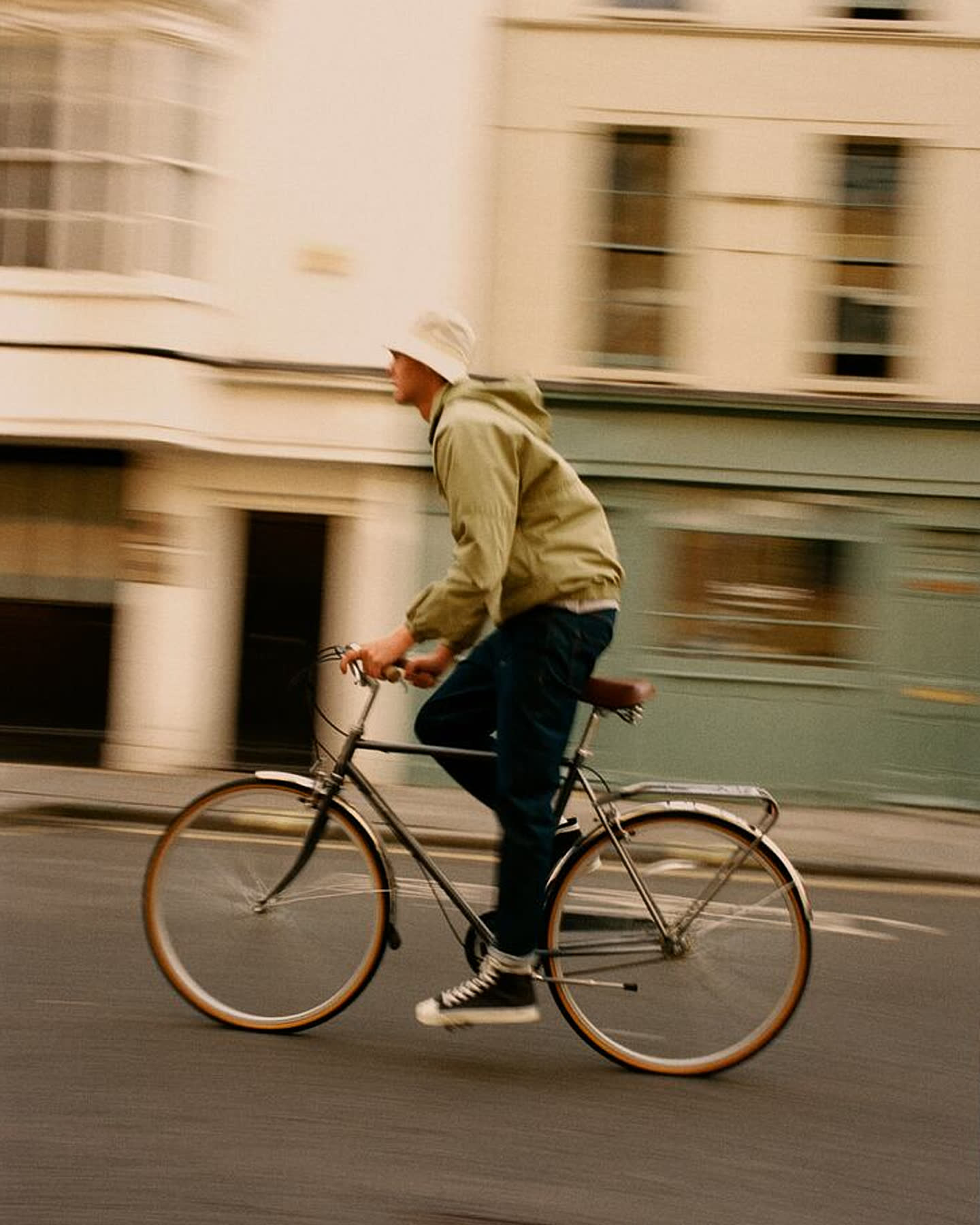 Darwin Gray riding a steel-framed bicycle through London for Portobello Road.