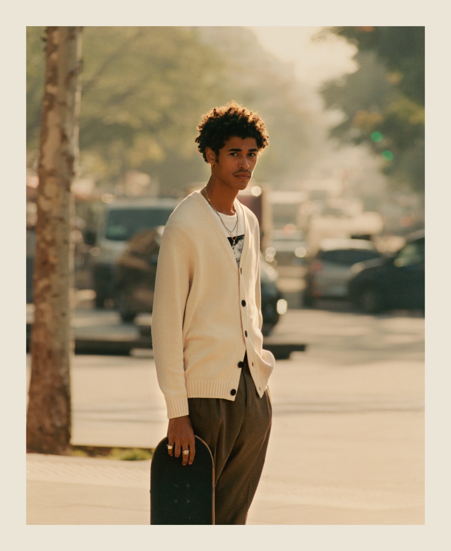 A skater in a cream cardigan in the afternoon light.