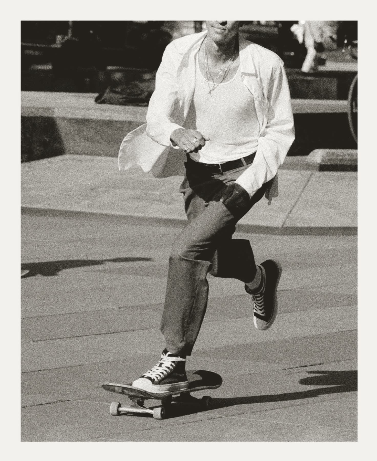 A skater moving across the pavers in black and white.