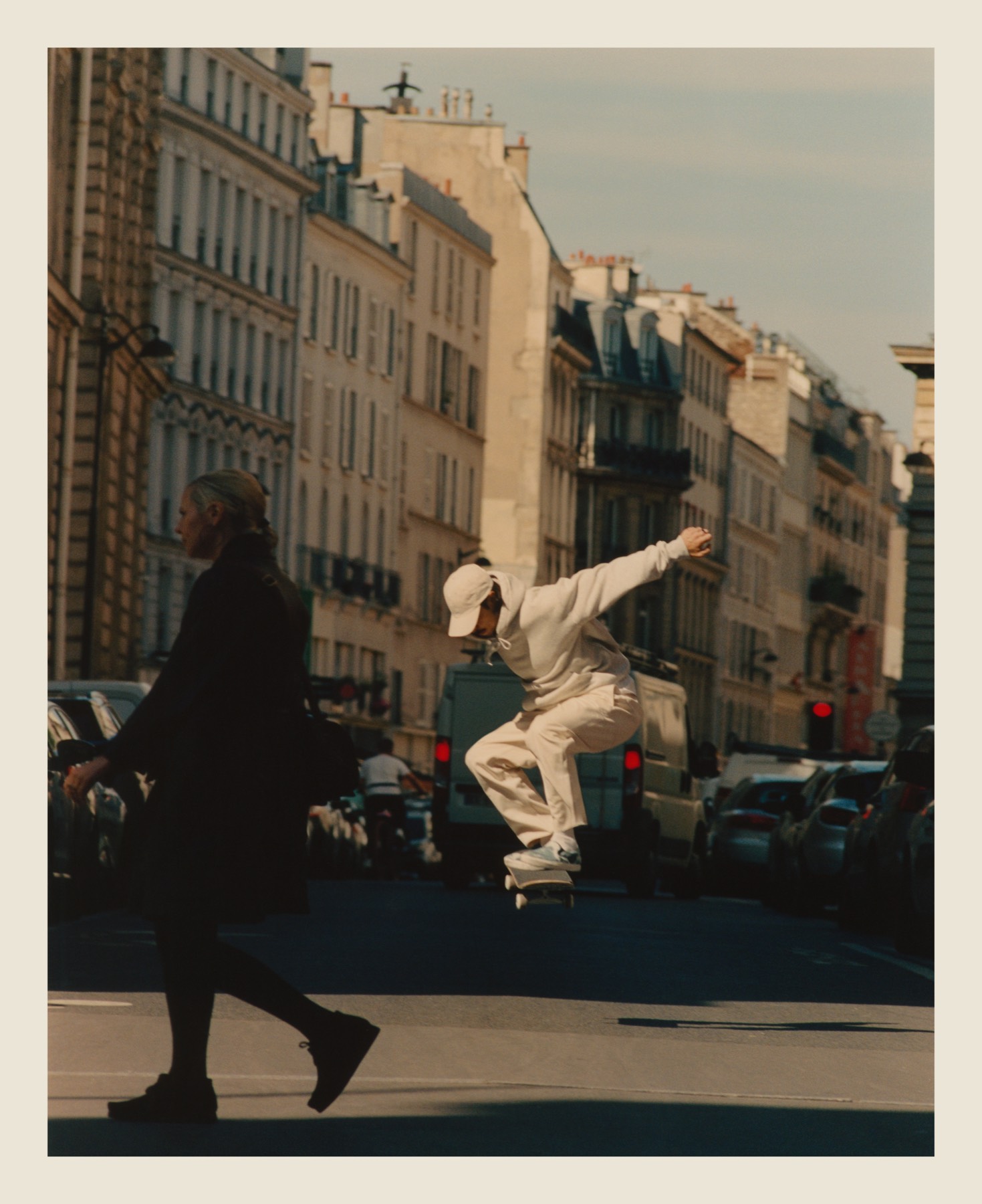 A skater moving down a Paris street at sunset.