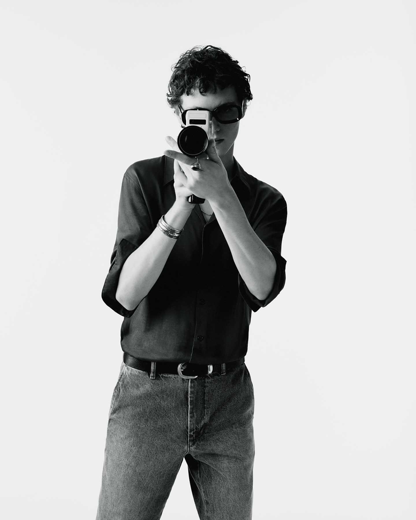 A model holding a camera in black silk for Zara.