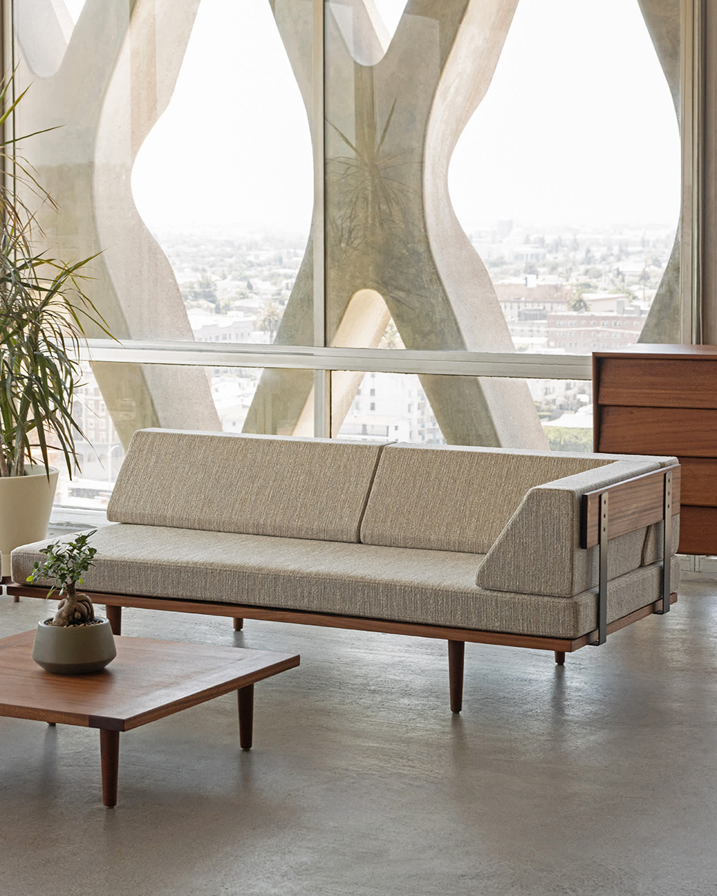 Solid Sapele sofa and coffee table arranged against the American Cement Building’s concrete frame.