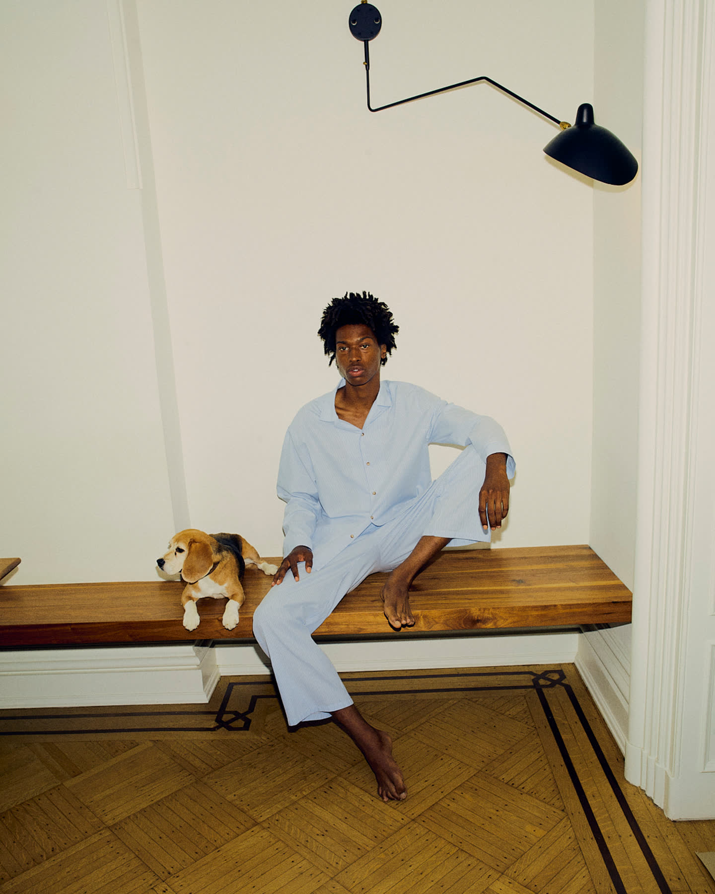 Tamel Lee seated with a dog in a light-filled room.