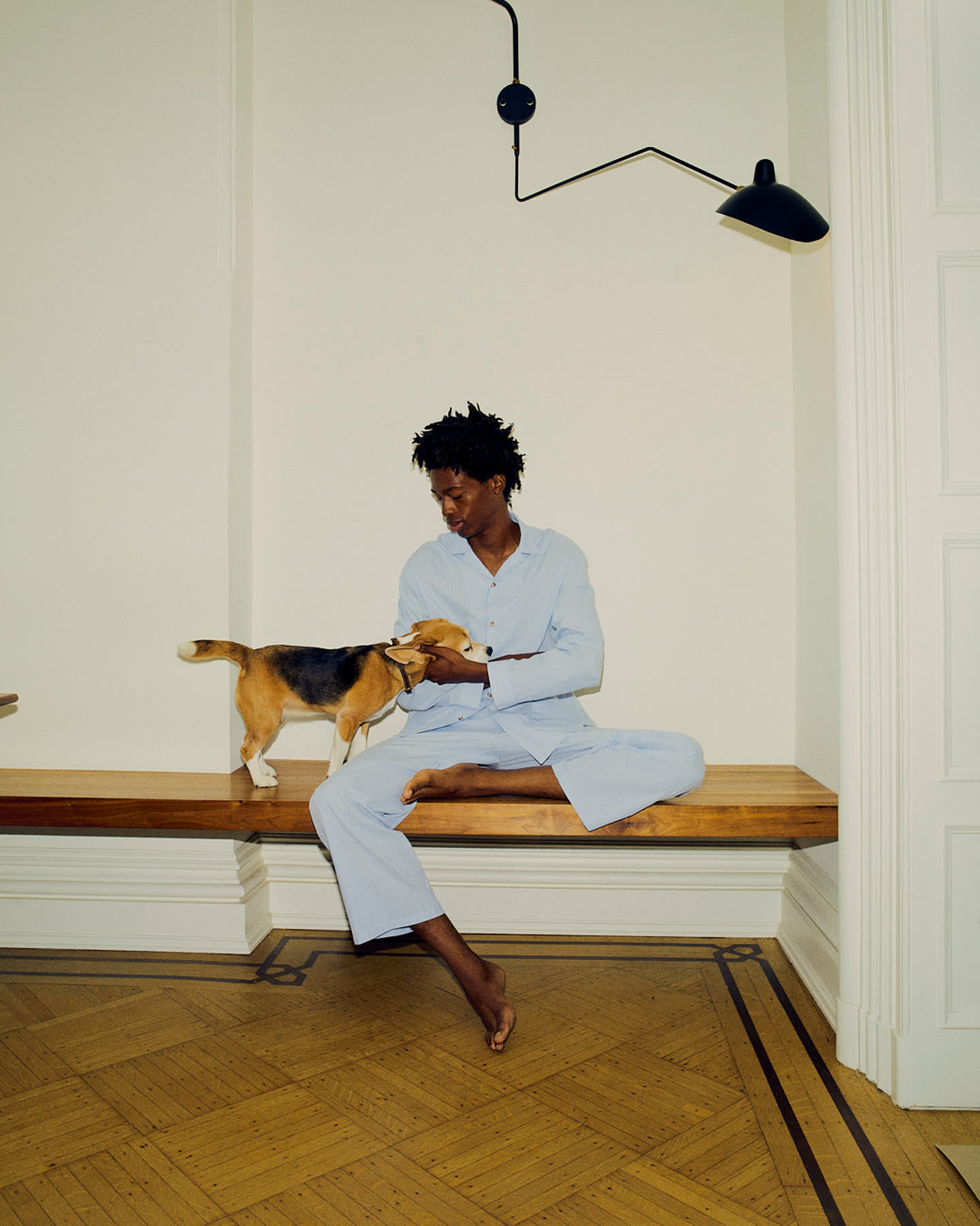 Tamel Lee sitting with the dog on a wood bench.