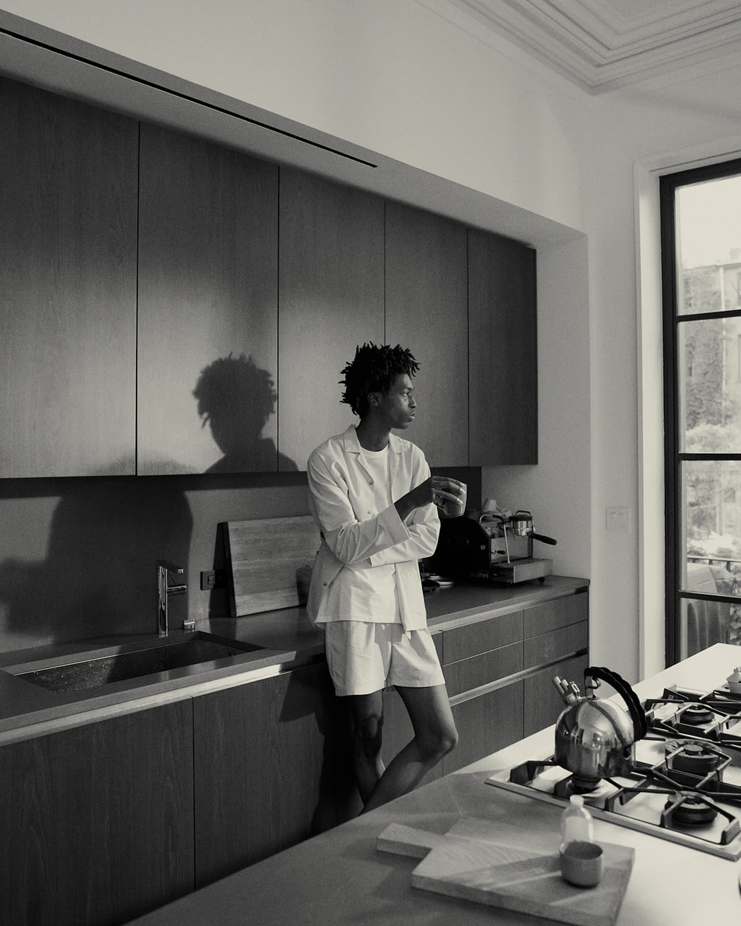 Tamel Lee standing in the kitchen with coffee.