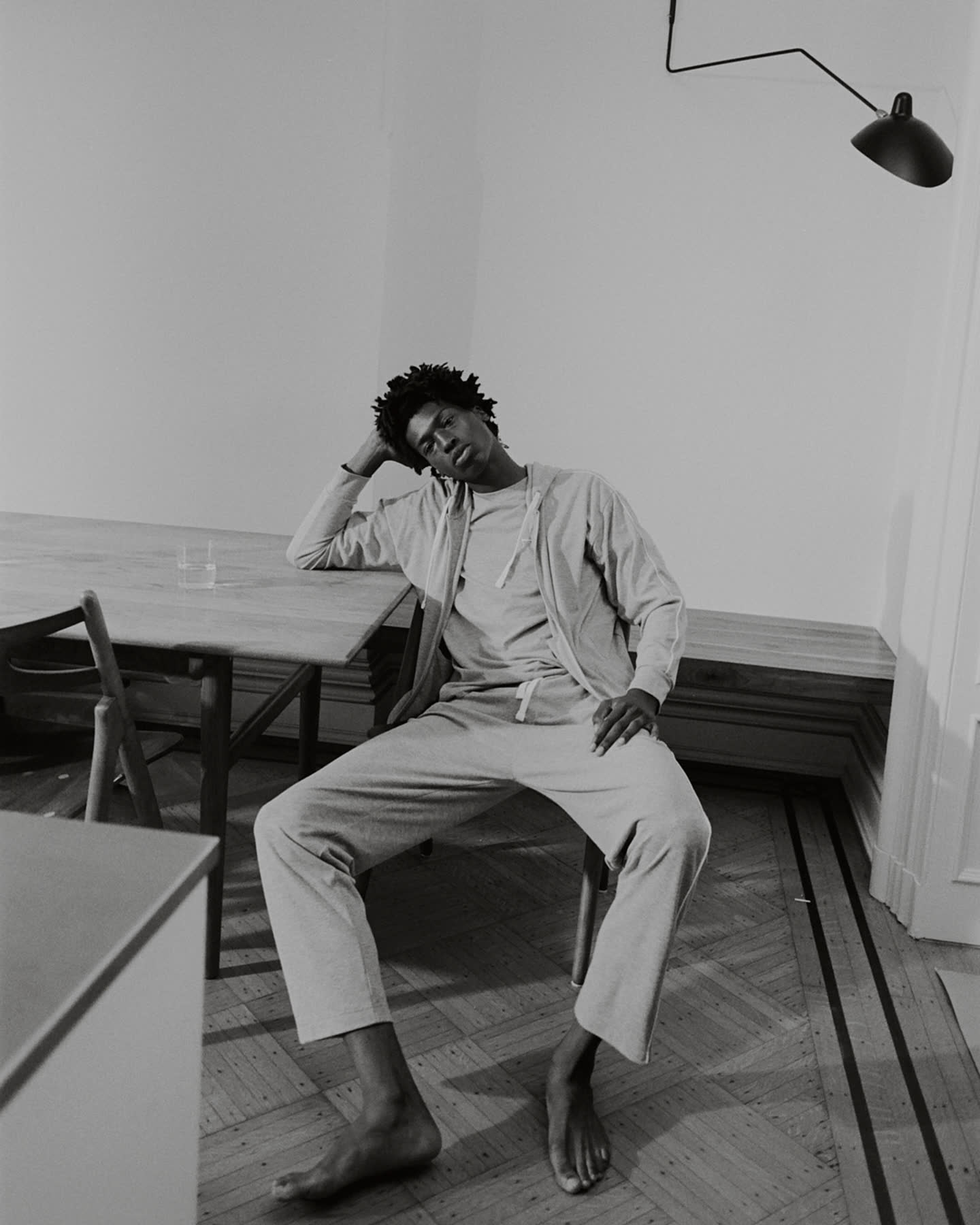 A black-and-white portrait of Tamel Lee seated at the dining table.